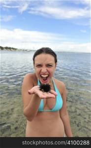 Woman holding an urchin on the beach in Brazil