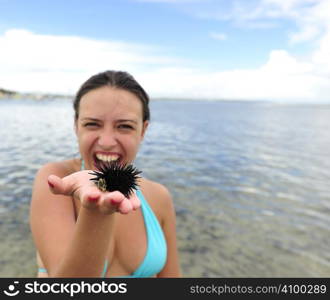 Woman holding an urchin on the beach in Brazil