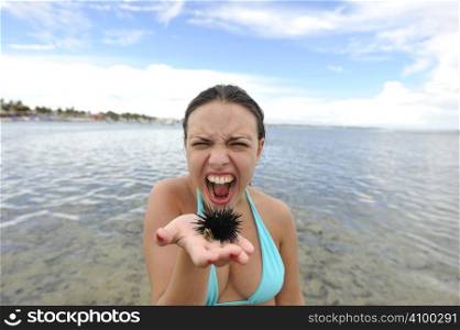 Woman holding an urchin on the beach in Brazil