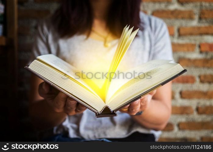 Woman holding and reading book.