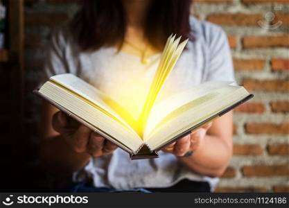 Woman holding and reading book.