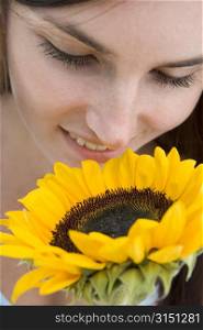 Woman holding and smelling a sunflower