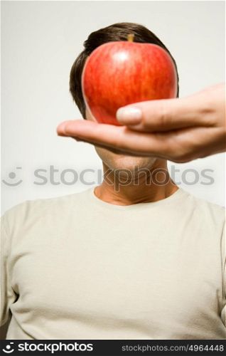 Woman holding apple over man&rsquo;s face