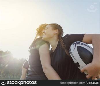 woman holding ball embracing her team mate