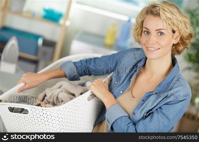 woman holding basket of dirty clothing