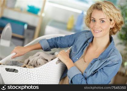 woman holding basket of dirty clothing