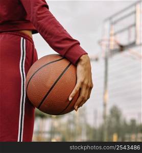 woman holding basketball her legs