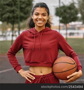 woman holding basketball outdoors