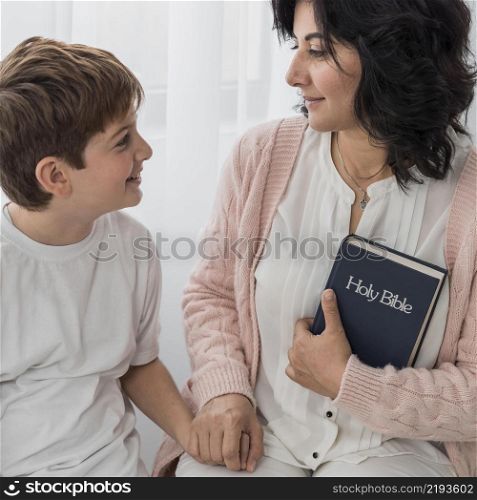 woman holding bible with her child