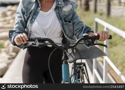 woman holding bike by handlebar grips