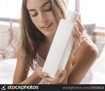 woman holding body lotion self care home