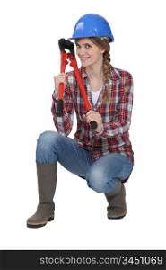 Woman holding bolt cutter whilst in crouching position