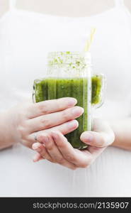 woman holding bottle green smoothie