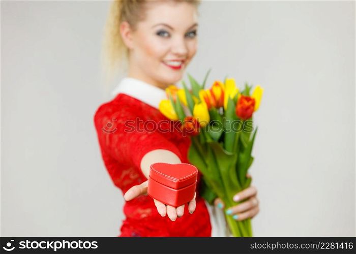 Woman holding bouquet of tulips flower and gift box in heart shape. Womans day, 8 march present.. Woman holding tulips and gift