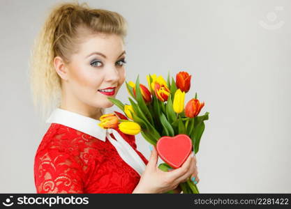 Woman holding bouquet of tulips flower and gift box in heart shape. Womans day, 8 march present.. Woman holding tulips and gift