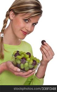 Woman holding bowl of grapes on white background