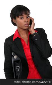 Woman holding briefcase whilst on the telephone