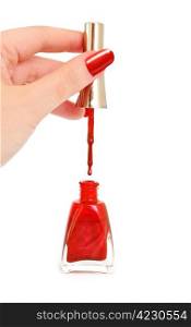 Woman holding brush over opened bottle of red nail polish