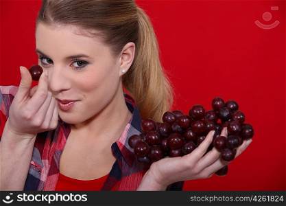 Woman holding bunch of red grapes