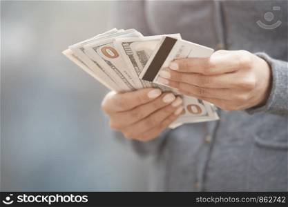 Woman holding cash money and credit card