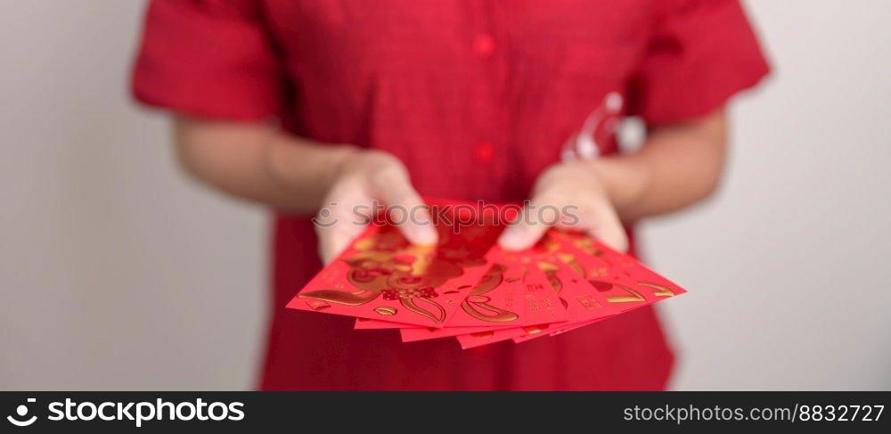 Woman holding Chinese red envelope, money gift for happy Lunar New Year holiday