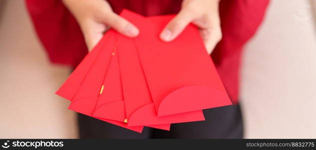 Woman holding Chinese red envelope, money gift for happy Lunar New Year holiday