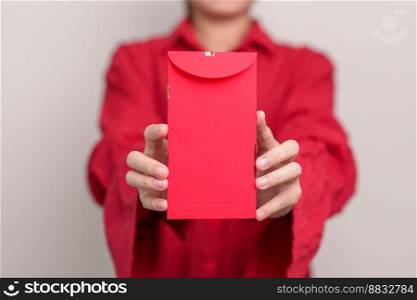 Woman holding Chinese red envelope, money gift for happy Lunar New Year holiday