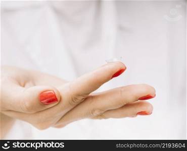 woman holding contact lenses her finger