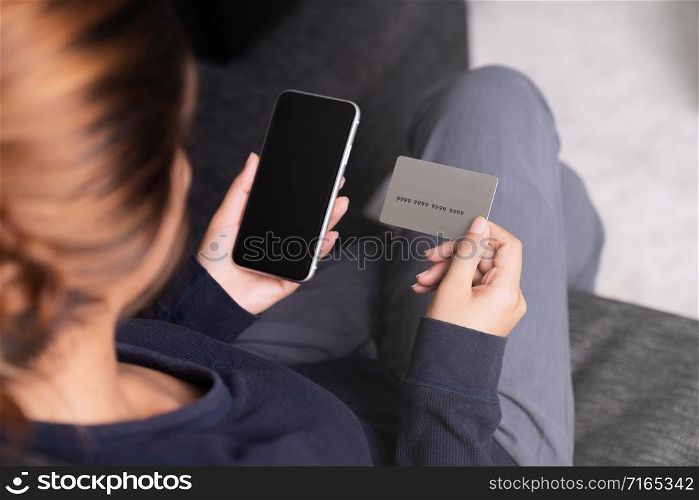 woman holding credit card and smartphone