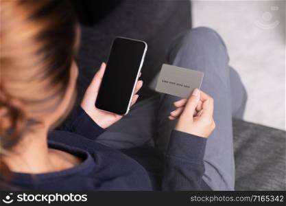 woman holding credit card and smartphone