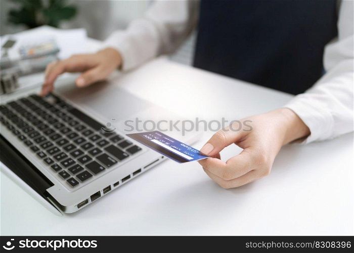 Woman holding credit card and using laptop computer for Internet online e-commerce shopping spending money Online shopping laptop technology concept . Online shopping pay by credit card concept.