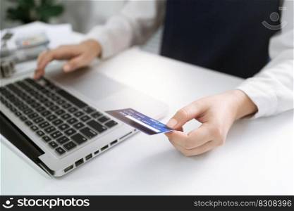 Woman holding credit card and using laptop computer for Internet online e-commerce shopping spending money Online shopping laptop technology concept . Online shopping pay by credit card concept.