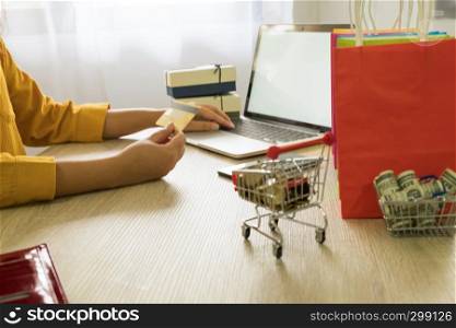 Woman holding credit card and using laptop for shopping online
