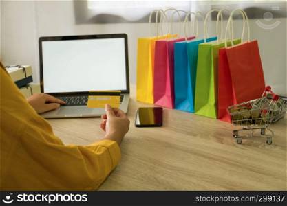 Woman holding credit card and using laptop for shopping online
