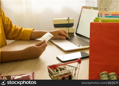 Woman holding credit card and using laptop for shopping online.