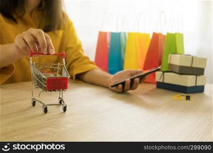 Woman holding credit card and using smartphone for shopping online