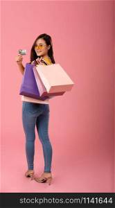 woman holding credit card & shopping bags. consumerism shopaholic lifestyle studio shot