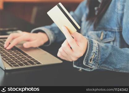 woman holding credit card using computer for shopping online