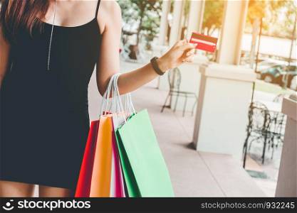 Woman holding credit crad enjoying shopping Street