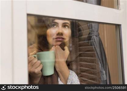 woman holding cup coffee while being covered with blanket 2