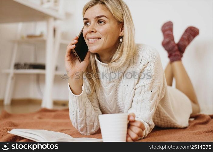 woman holding cup tea talking phone