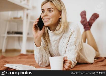 woman holding cup tea talking phone