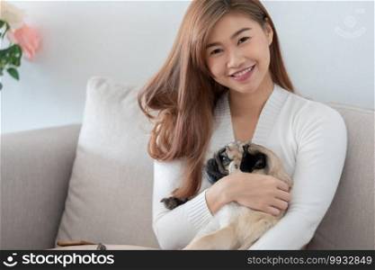 woman holding dog pug breed and sleep in her arm relax and comfortable in living room