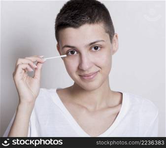 woman holding ear cotton bud