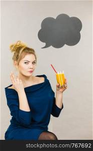 Woman holding fresh orange grapefruit juice. Healthy fruit drink smoothies concept, black thinking or speech bubble next to her.. Woman holding fresh orange juice