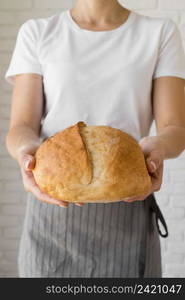 woman holding fresh round bread