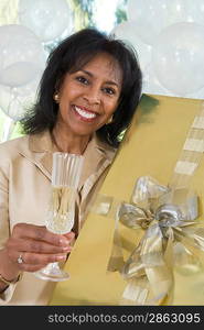 Woman holding gift and glass of champagne