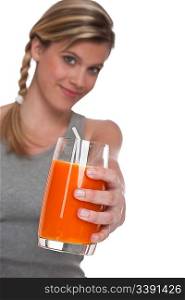 Woman holding glass of carrot juice on white background, focus on glass