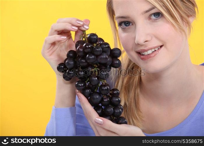 Woman holding grapes.
