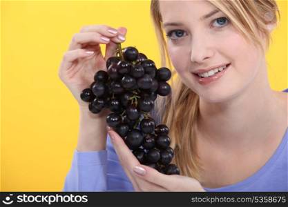 Woman holding grapes.